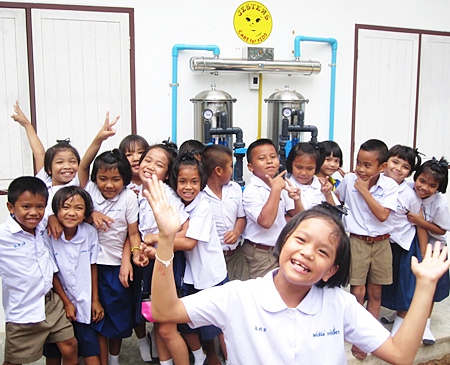 Kids at Nikom #7 show how happy they are with the new drinking water project.